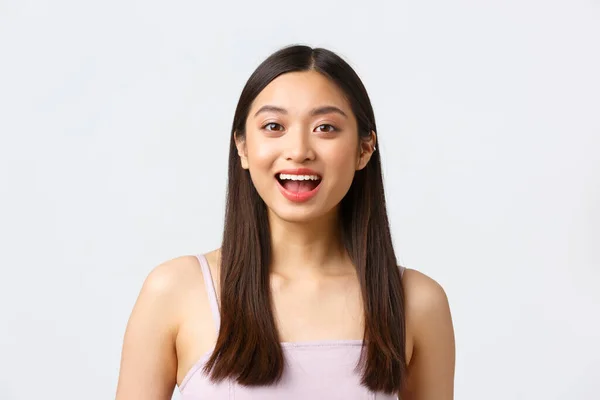 Conceito de beleza, moda e emoções das pessoas. Close-up retrato de bela menina asiática animado sorrindo surpreso, boca aberta maravilhado e espantado, de pé fundo branco — Fotografia de Stock