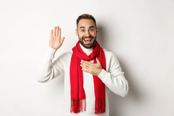 Attraktiver kaukasischer Mann, der die Wahrheit sagt, die Hand am Herzen hält und schwört, Versprechen macht, während er vor weißem Hintergrund steht — Stockfoto