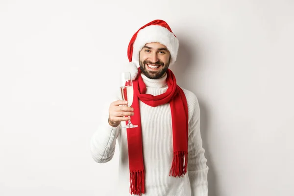 圣诞派对和假期的概念。英俊的年轻人留着胡子，在新年前夕举杯庆祝，手里拿着香槟，笑容满面，背景洁白 — 图库照片