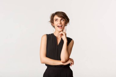 Düşünceli ve kurnaz genç bir kadının portresi. Düşünürken, seçim yaparken, beyaz arka plan.