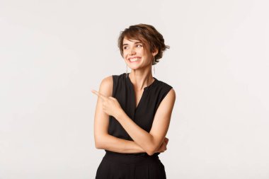 Tasasız, zarif giyinmiş güzel bir kadının portresi sol üst köşeyi gösteriyor ve bakıyor, gülümsüyor, mutlu, beyaz arka plan