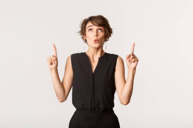 Siyah elbiseli zarif bir bayanın şaşaalı bir ifadeyle işaret edişi.