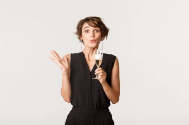 Seremoniyi izleyen, şampanya içen, şaşkın bakışlı güzel kız.