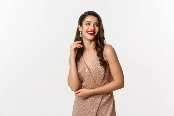 Mulher elegante de pé em vestido de noite e maquiagem, rindo e celebrando o Ano Novo, vestindo roupa para festa formal, de pé sobre fundo branco — Fotografia de Stock