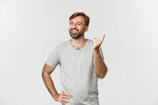 Imagem de homem barbudo bonito sorrindo e agitando o dedo para elogiá-lo, rindo sobre algo engraçado, de pé sobre fundo branco — Fotografia de Stock