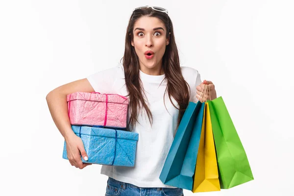 Shopping, vacances et style de vie concept. Portrait de jeune fille excitée et amusée dépêchez-vous d'acheter des cadeaux, les derniers jours de promo offrent des réductions, tenant des cadeaux et des sacs de magasin — Photo