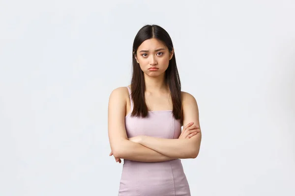 Mulheres de luxo, festa e feriados conceito. Grimacing e triste jovem bonito menina asiática em vestido de noite, sentindo-se mal-humorado na noite do baile, cruz braços peito e olhando câmera incomodado, fundo branco — Fotografia de Stock