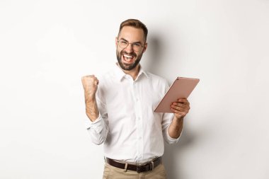 Başarılı iş adamları online kazanmaktan, dijital tablette okumaktan, yumruk pompalamaktan, zafer kazanmaktan, beyaz arka planda ayakta durmaktan mutlu olurlar.