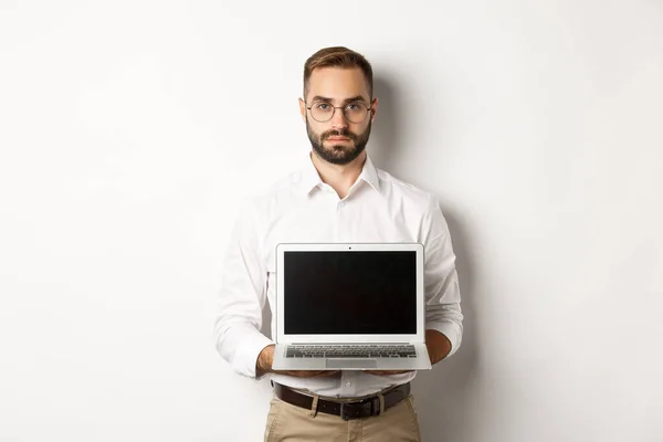 Zelfverzekerd beheren tonen laptop scherm, uw logo of promo, staande over witte achtergrond — Stockfoto