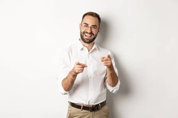 Hombre de negocios satisfecho apuntando con los dedos a la cámara, alabándote, aprobándote o como algo, fondo blanco — Foto de Stock