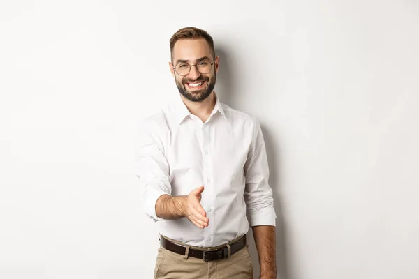 Selbstbewusster Geschäftsmann reicht Hand zum Händedruck, grüßt Geschäftspartner und lächelt, steht über weißem Hintergrund — Stockfoto