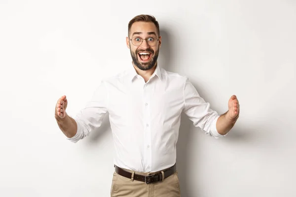 Homme d'affaires étonnant montrant un gros objet, décrire quelque chose de grand et de l'air excité, debout sur fond blanc — Photo