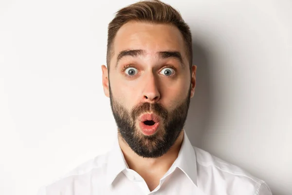 Emoties en mensen concept. Headshot van de mens uiten verrast en verwondering, zeggen wow, staande over witte achtergrond — Stockfoto