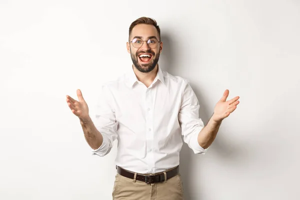 Empresário surpreso e feliz recebê-lo, olhando animado e sorridente, de pé contra fundo branco — Fotografia de Stock