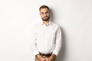 Hüzünlü ve kasvetli ofis, beyaz arka plana karşı yorgun ve somurtkan durmayı başarır.