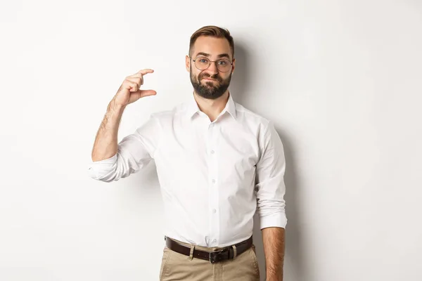 Empresário barbudo descontente mostrando pequeno gesto, olhando decepcionado, de pé contra fundo branco — Fotografia de Stock