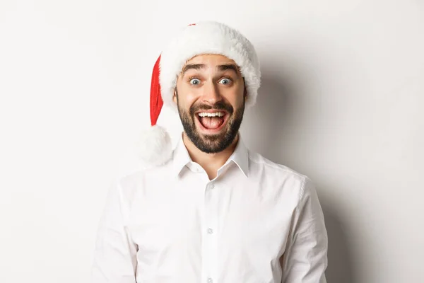 Close-up de cara barbudo feliz em Papai Noel, olhando surpreso, comemorando o Natal, de pé sobre fundo branco — Fotografia de Stock