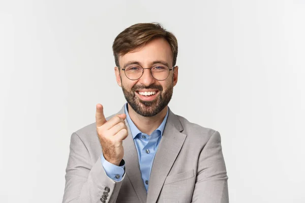 Close-up de empresário bonito com barba, vestindo terno cinza e óculos, elogiando bom ponto, sorrindo satisfeito, de pé sobre fundo branco — Fotografia de Stock