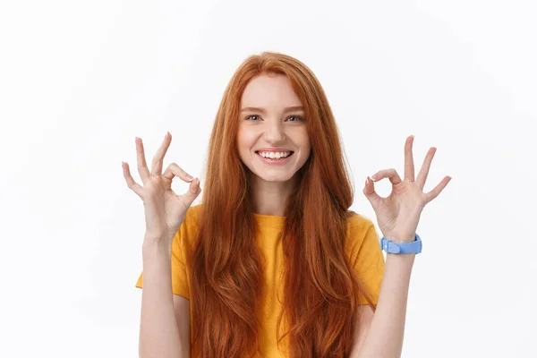 Glückliche junge Frau zeigt ok Zeichen mit den Fingern und zwinkert isoliert auf weißem Hintergrund. — Stockfoto