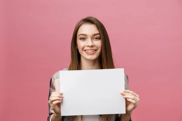 Close up portrait of positive laughing woman smiling and holding white big mockup poster isolated on pink background — Stock Photo, Image