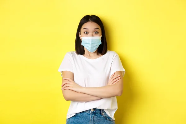 Ковед, охорона здоров'я та пандемія. Азійка у білій футболці та медичній масці на грудях, здивована камерою. — стокове фото