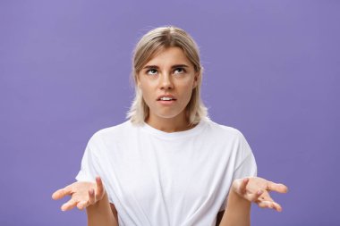 Hayır, hiçbir fikrim yok. Tedirgin olmuş güzel Avrupalı bir kadının portresi, sarışın, yuvarlak gözlü, hayal kırıklığına uğramış bir ifadeyle omuz silkmiş, elleri havada, habersiz bir hareketle omuz silkiyor.