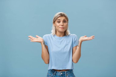 Nasıl yardımcı olabilirim bilmiyorum. Üzgünüm. Belirsiz kasvetli kız arkadaşın portresi. Pişmanlık duyuyor. Elleri omuzlarının yanında, kaşlarını çatıyor, dudaklarını büzüyor.