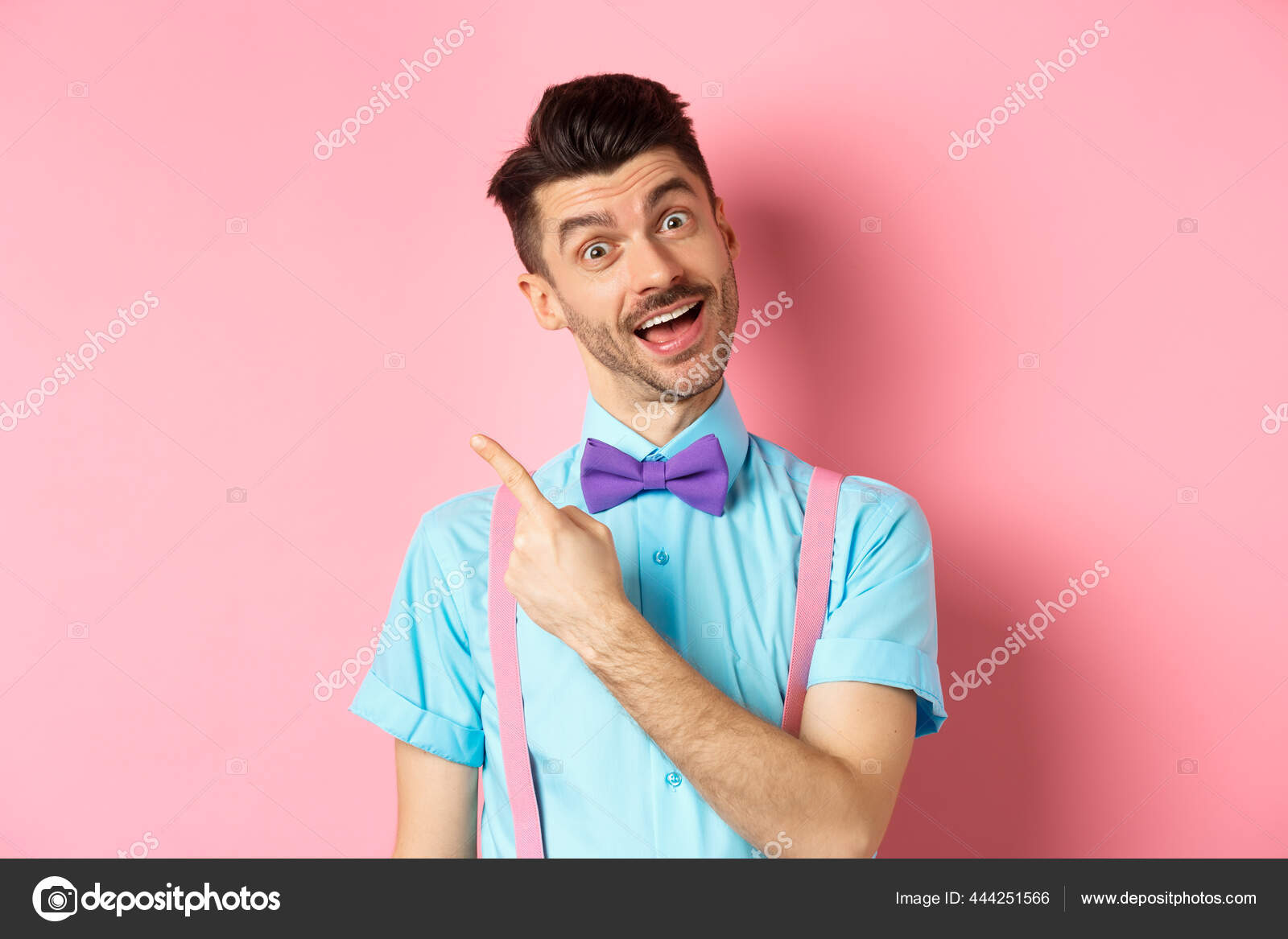 Funny male model in bowtie, tilt head and pointing finger left