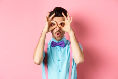 Reklamları kontrol ediyorum. Papyonlu etkileyici bir adam, el dürbününden bakıyor ve şöyle diyor: Vay canına, havalı reklamlara bakıyor, pembe arka planda duruyor.