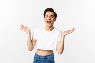 Lgbtq ve gurur konsepti. Ekinler içindeki yakışıklı genç adam elini kaldırıyor ve şaşırmış, sevinçli, beyaz arka planda duruyor.