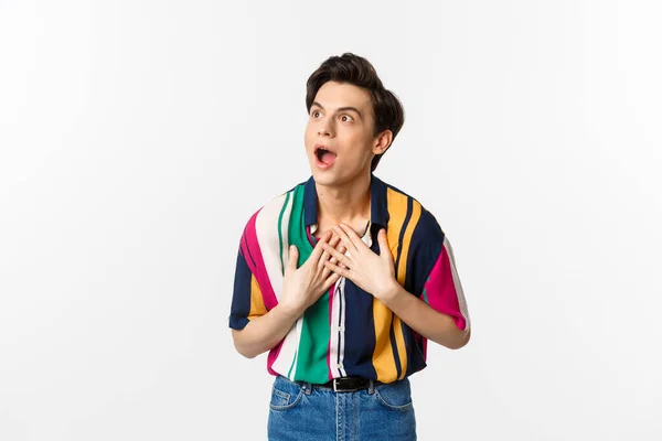 Impressed young handsome man looking at upper left corner, express disbelief and amazement, seeing promo offer, white background — Stock Photo, Image