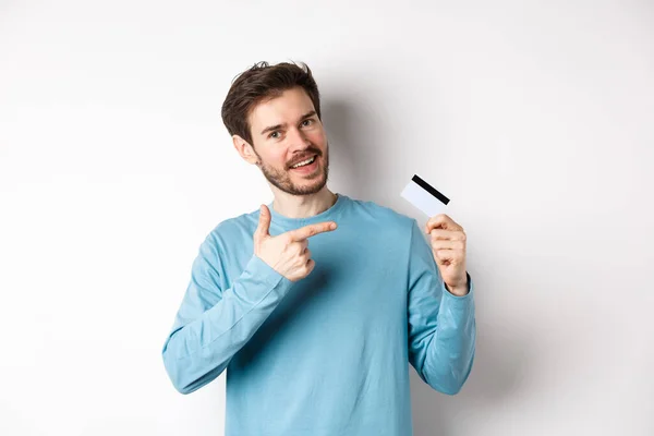 Bonito barbudo homem recomendando cartão de crédito bancário, de pé sobre fundo branco — Fotografia de Stock