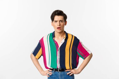 Kafası karışmış ve üzgün genç bir adamın beyaz arka planda hayal kırıklığına uğramış bir şekilde kameraya bakması.