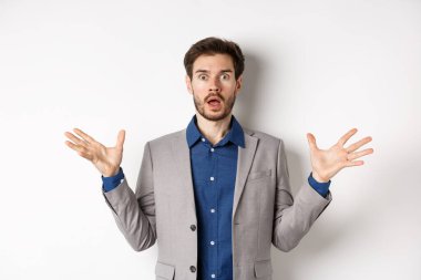 Ceketli şok olmuş sakallı adam ellerini yana yatırdı, nefes nefese kaldı ve endişeli görünüyordu, pembe arka plan giysisine karşı duruyordu.