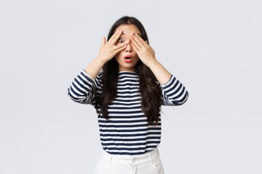 Yaşam tarzı, güzellik ve moda, insanların duygu konsepti. Rüya gibi Asyalı kız sürpriz bekliyor. Asyalı kadın gözlerini kapat ve parmaklarının arasından neler olduğunu merak et.