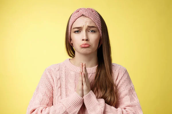 Clingy sad whining girlfriend bagging buy her dress grimacing pouting and frowning upset, pressing palms together in pray, asking favour, apologizing, praising friend to help over yellow background — Stock Photo, Image