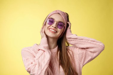 Güzel, büyüleyici, tasasız, tatile hazır genç bir kadının belden yumağı, bavullar kışın taşınır, seyahat eder, mutlu bir şekilde gülümser, yüzlerine dokunur, güneş gözlüklü süveter giyer.