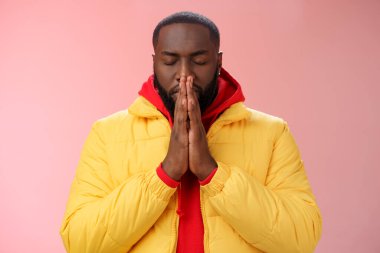 Serious-looking determined young focused african-american man prepare will important meeting press palms together hands pray close eyes supplicating praying make wish, standing pink background clipart