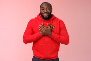 Memnuniyetle Afrika kökenli Amerikalı gülümseyen genç sakallı adam el ele tutuşun yürekten gülümseyerek gülümseyin.