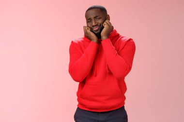 Sevimlilikten eriyen erkek kalbi ve sevimli sahne, kıvrılmış dudaklar, şapşal gay kafa avuçları etkilenmiş görünüyor güzel kedi yavrusu iç açıcı sahne, pembe arka plan mutlu duruyor.