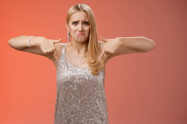 Mızmızlanan, üzgün, gümüş elbiseli, üzgün, sarışın bir kadın. Erkek arkadaşı, mezuniyet balosunda ayrıldı. Mutsuz bir şekilde dikiliyor.