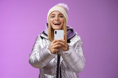 Heyecanlı, çekici, sarışın kız arkadaşı elinde akıllı telefonla video kaydediyordu. Erkek arkadaşı, snowboard yaparken ilk kez anıları yakalıyordu. Mobil kamera mutlu bir şekilde mor arka planda duruyordu.