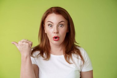 Yakın plan şaşkın kızıl saçlı, orta yaşlı, kıvrık dudaklı ev hanımı, 