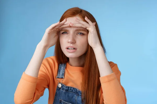 Preocupado clingy ruiva namorada espionagem namorado par de distância squinting foco vista olhar longe segurar as mãos testa cobrir os olhos luz solar de pé concentrado fundo azul — Fotografia de Stock