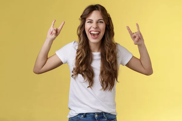 Menina se divertindo excelente concerto incrível desfrutar de show de música ao vivo rock-n-roll gesto de heavy metal gritando otimista feliz participar festa festival legal sorrindo amplamente mostrar língua ousado fundo amarelo — Fotografia de Stock