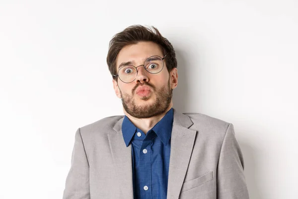 Tipo sobresaltado en gafas y traje, inclinarse hacia atrás y mirando sorprendido o asustado a la cámara, de pie sobre fondo blanco — Foto de Stock