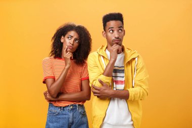 İki beyin bir beyinden iyidir. Düşünceli bir çift Afro-Amerikan arkadaşı şık şehir kıyafetleri içinde düşünceli bir duruşta durmuş kararlı ve odaklanmış bir şekilde akşamın nasıl geçeceğini planlıyorlar.
