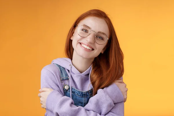 Tierna novia pelirroja europea romántica cabeza inclinada linda sonrisa encantadora dientes blancos cabeza inclinada abrazándose usando mejores amigos sudadera con capucha adorar nuevo traje sonriendo alegremente, fondo naranja — Foto de Stock