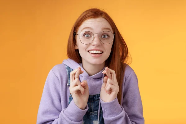 Chica emocionada viendo resultados cruzan los dedos buena suerte animando equipo favorito quiere ganar sueño hecho realidad emocionada boca abierta mirada amplia cámara esperanzador suplicante deseo cumplido, fondo naranja — Foto de Stock