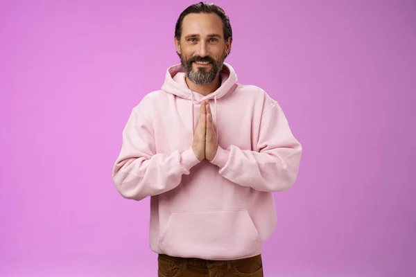 Peaceful attractive bearded mature mail model in trendy pink hoodie press palms together namaste praying gesture smiling delighted relaxed bowing buddhism faith, appreciating help, look thankful — Stock Photo, Image